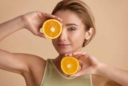 Frau mit Orangenscheiben macht Detox-Kur